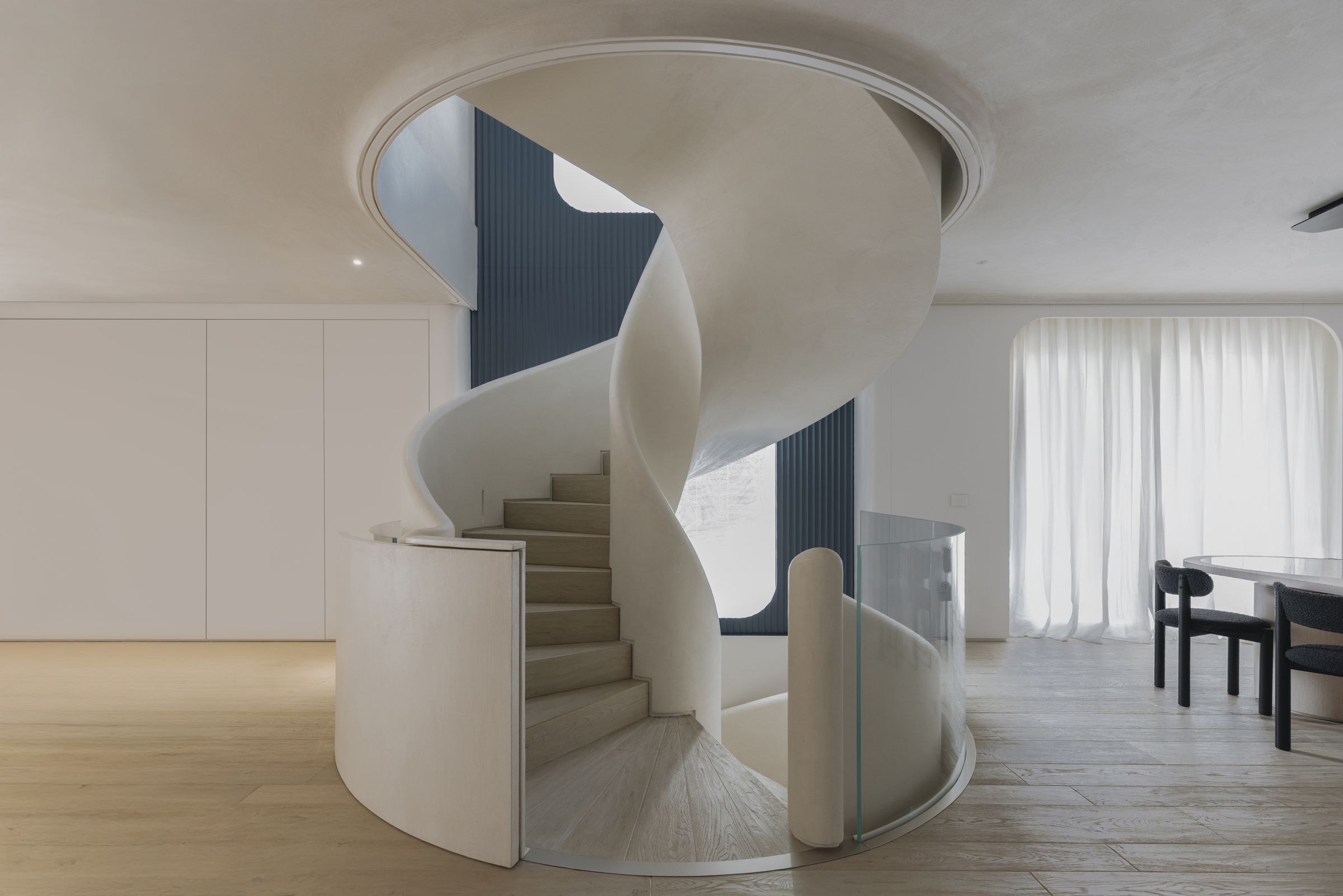 Scala elicoidale e pareti attrezzate bianche della Villa D.F.
